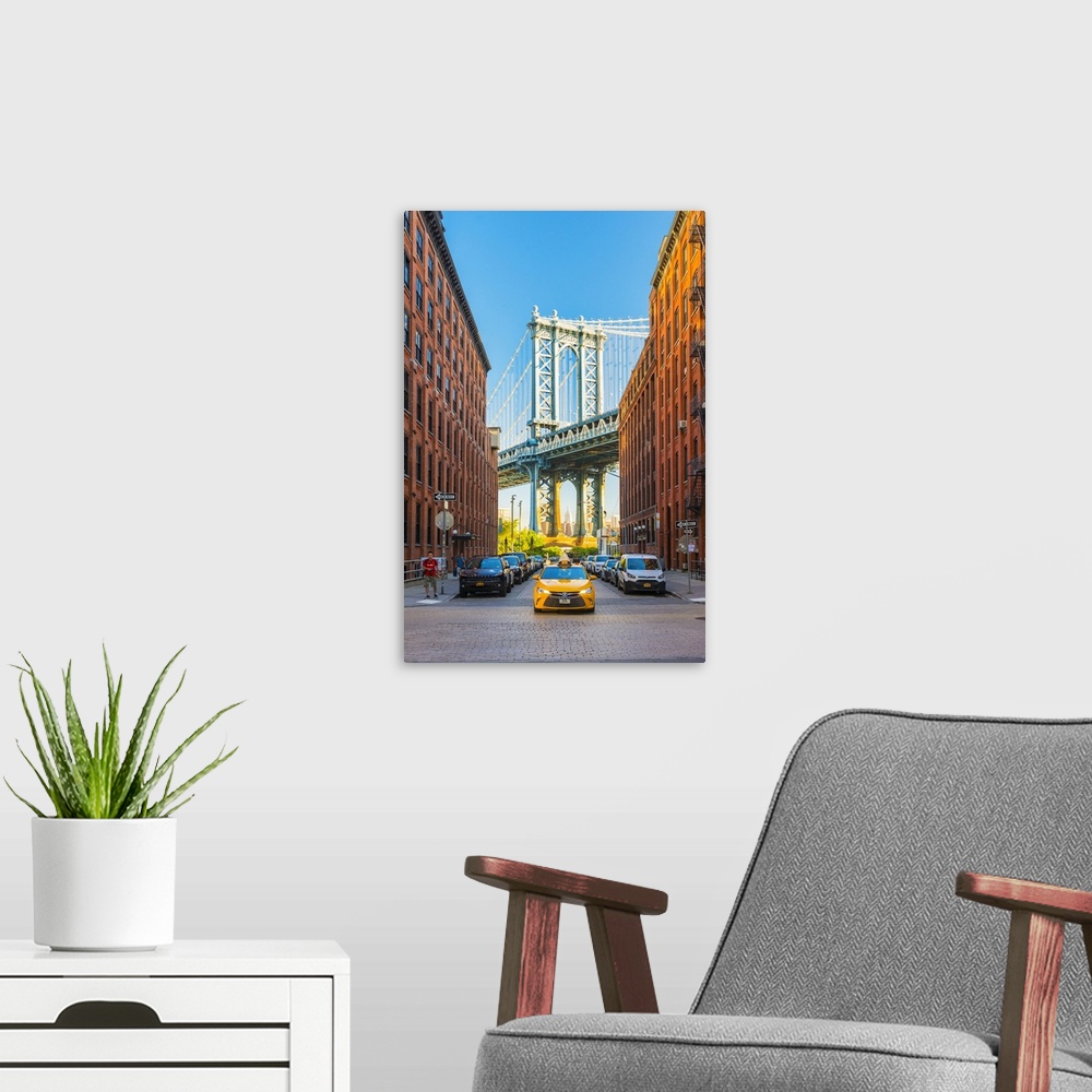 A modern room featuring Taxi passing under the Manhattan bridge with the Empire state building framed in the bridge, New ...