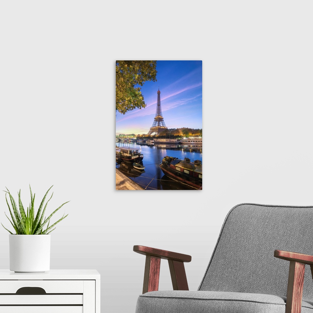 A modern room featuring Morning summer first lights on the Eiffel tower in Paris, France. Some boats and trees facing the...