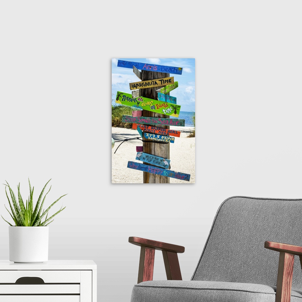 A modern room featuring A collection of colorful humorous signs on a wooden post on the beach.