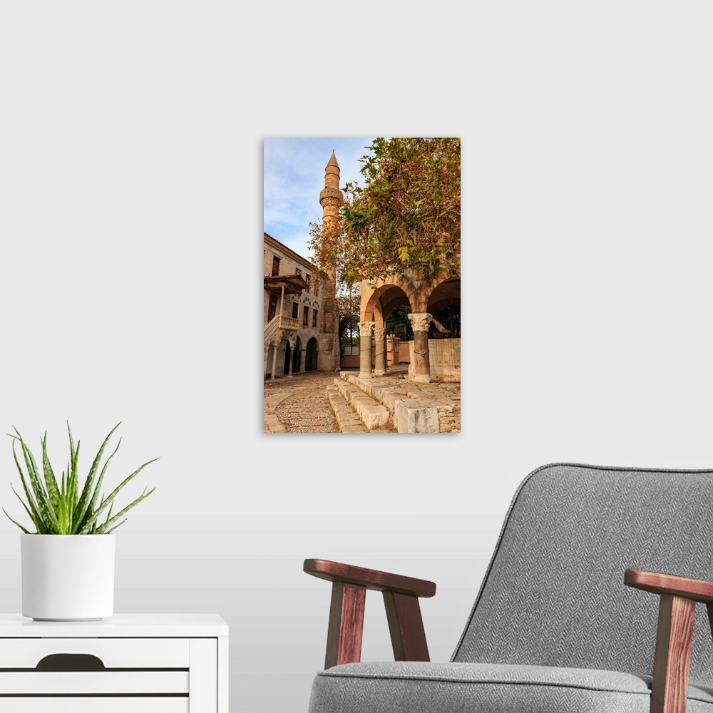 A modern room featuring Hippocrates Plane Tree, fountain and mosque, Plateia Platanou, cobblestone square in autumn, Kos ...