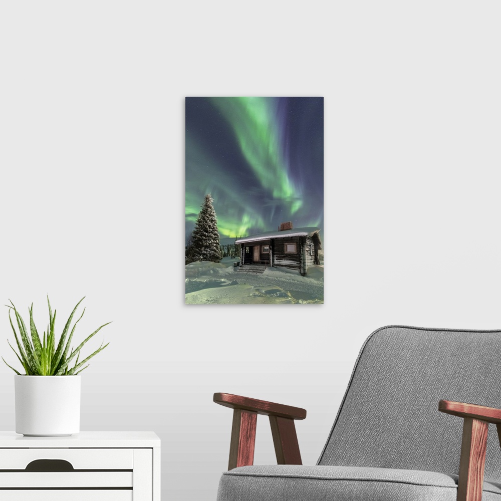 A modern room featuring The Northern Lights frame the wooden hut in the snowy woods, Pallas, Yllastunturi National Park, ...