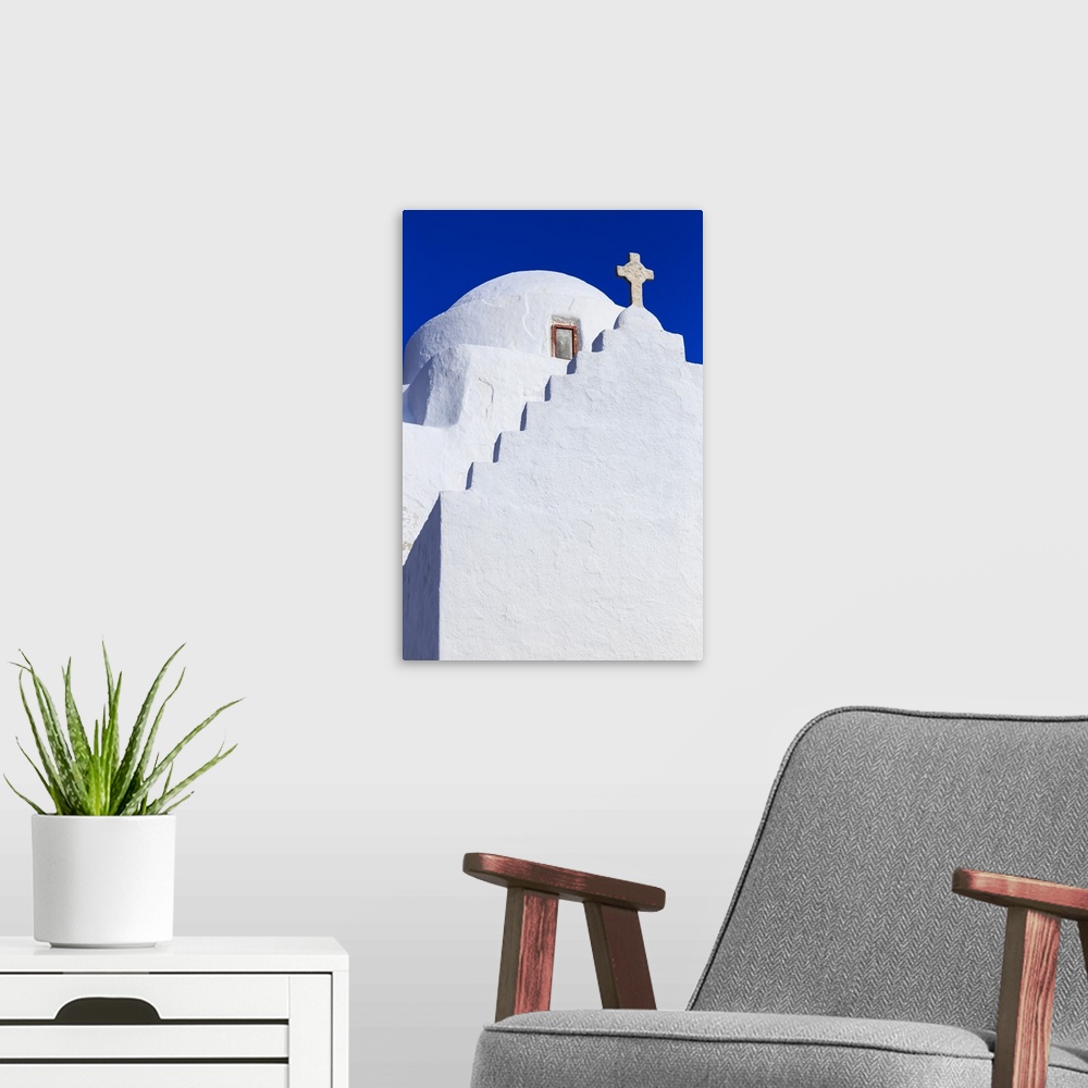 A modern room featuring Whitewashed Panagia Paraportiani, Mykonos most famous church, under a blue sky, Mykonos Town, Myk...
