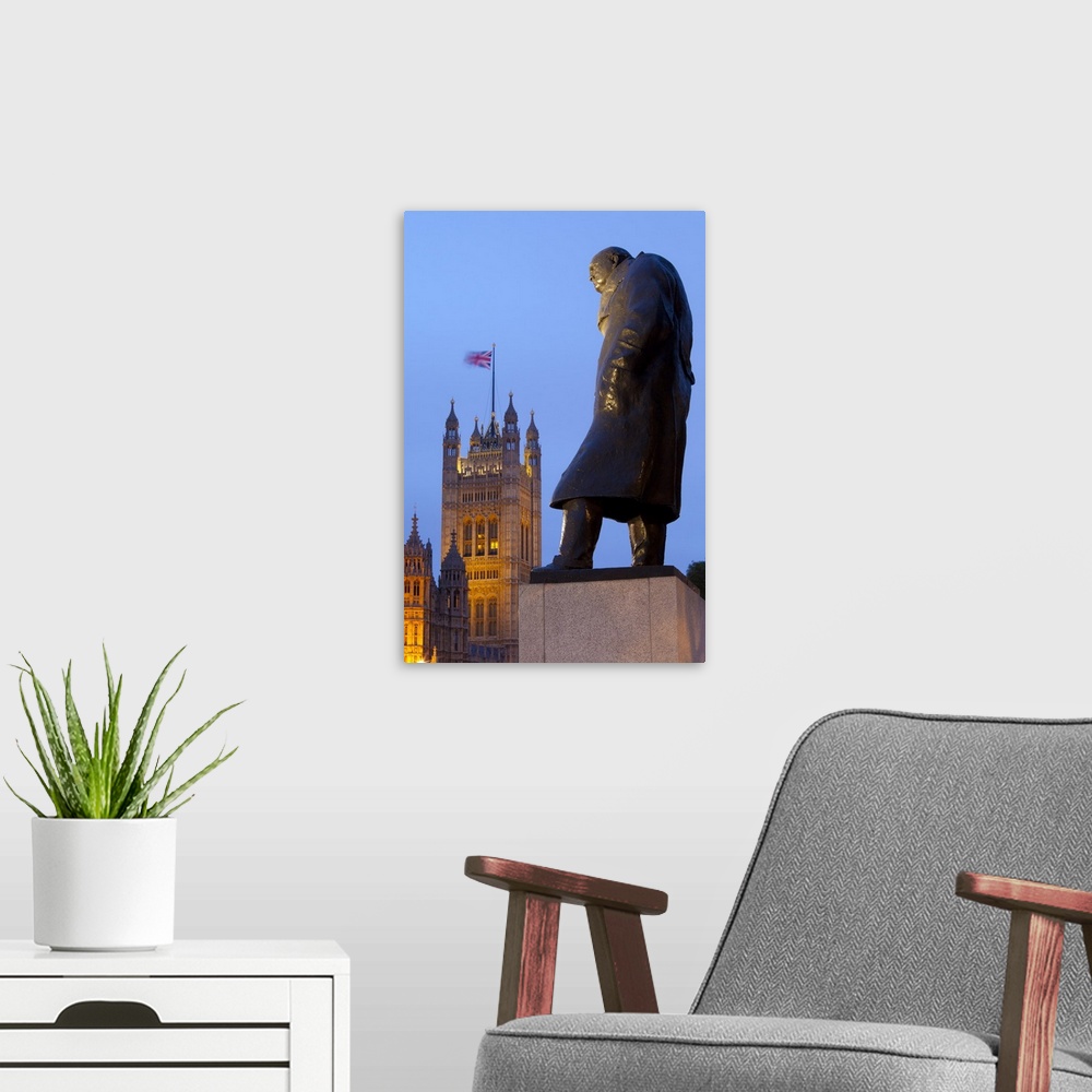 A modern room featuring Winston Churchill statue and Parliament at night, London, England, UK