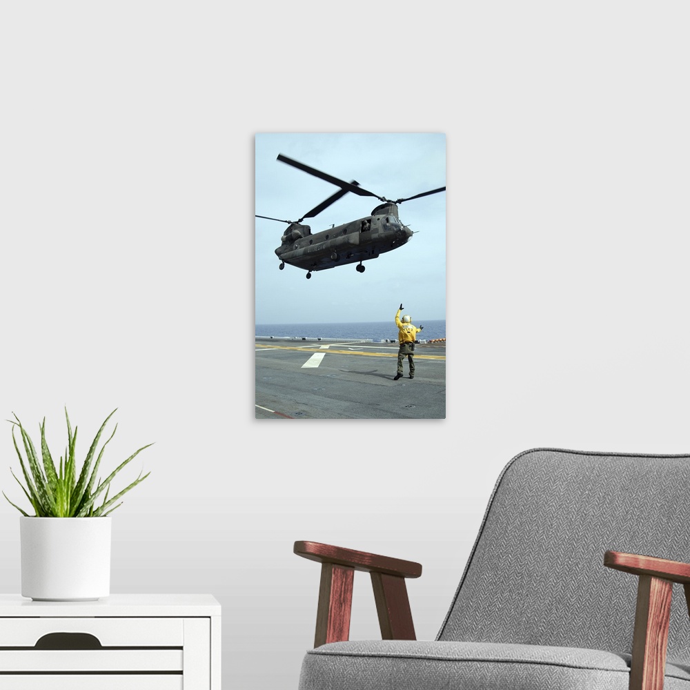 A modern room featuring Airman directs an Army CH-47 Chinook helicopter on the flight deck.