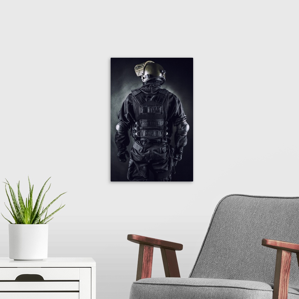 A modern room featuring Spec ops soldier on black background shot from behind.