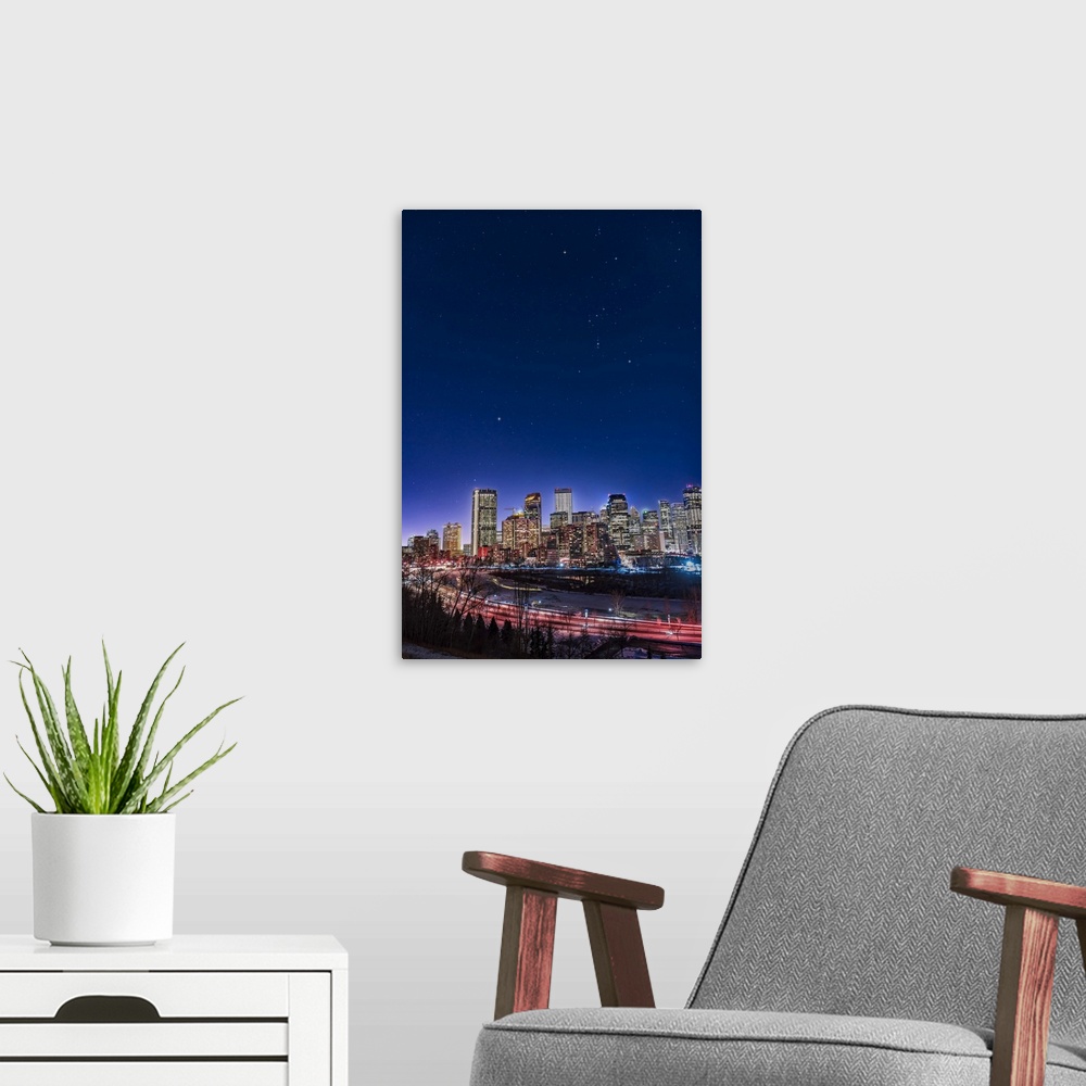 A modern room featuring An urban nightscape with the constellations of Orion and Canis Major over the skyline of Calgary,...