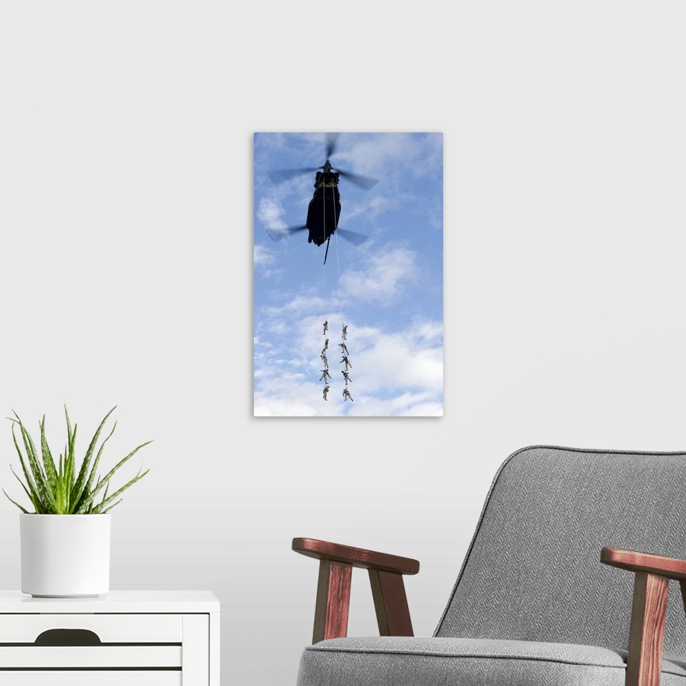 A modern room featuring U.S. Soldiers are suspended by a CH-47 Chinook helicopter.