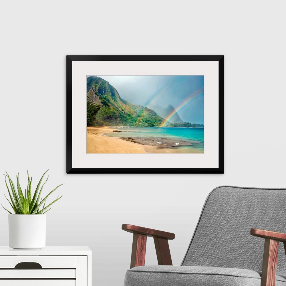 A modern room featuring A landscape photograph with double rainbows on a tropical beach with mountains in the background.