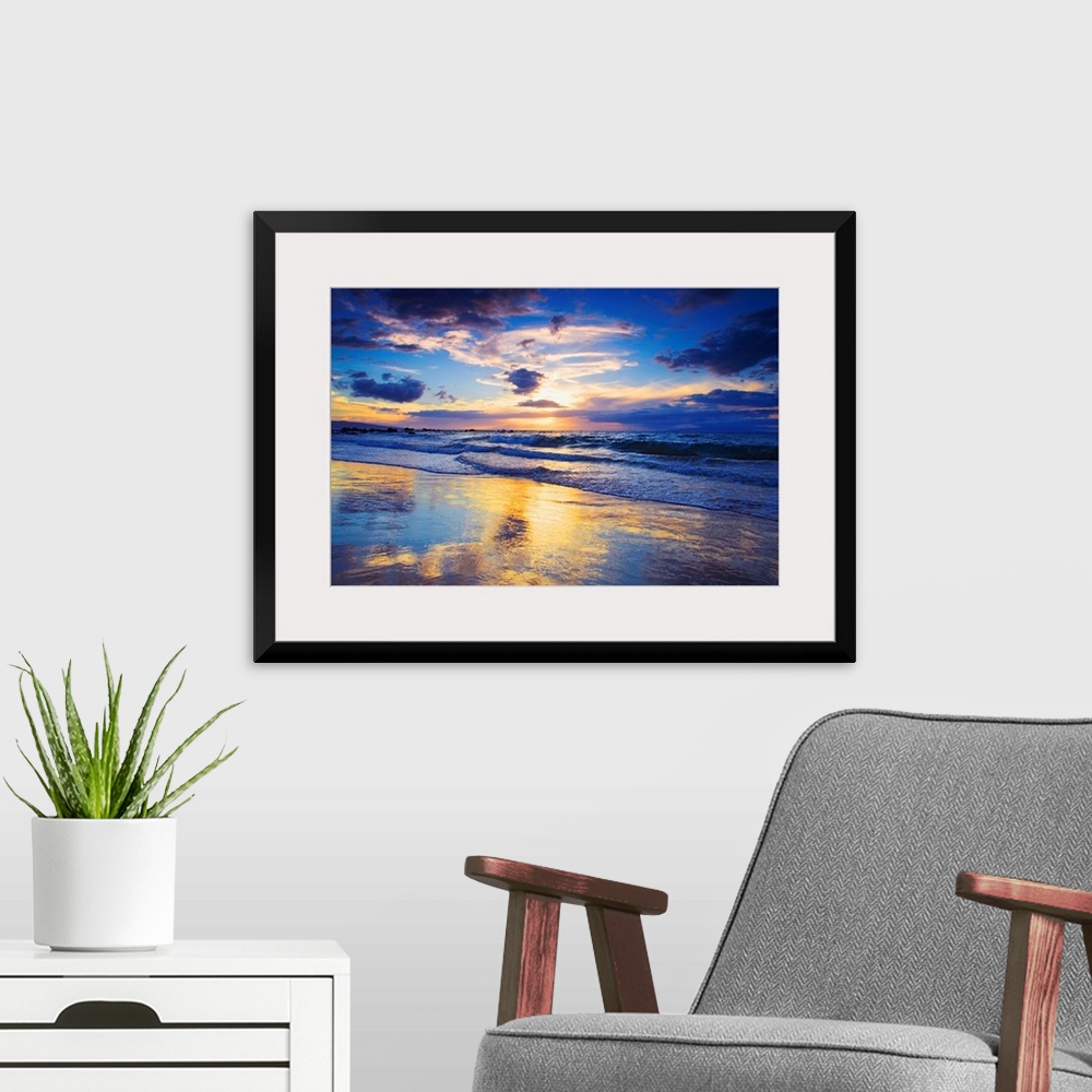 A modern room featuring Horizontal photograph on a large wall hanging of a vivid sunset glowing through clouds, over the ...