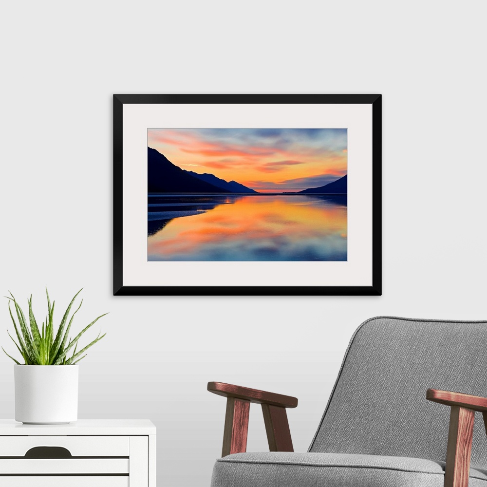 A modern room featuring Expansive photograph of the Turnagain Arm in the Cook Inlet in Alaska (AK) during sunset. Calm wa...