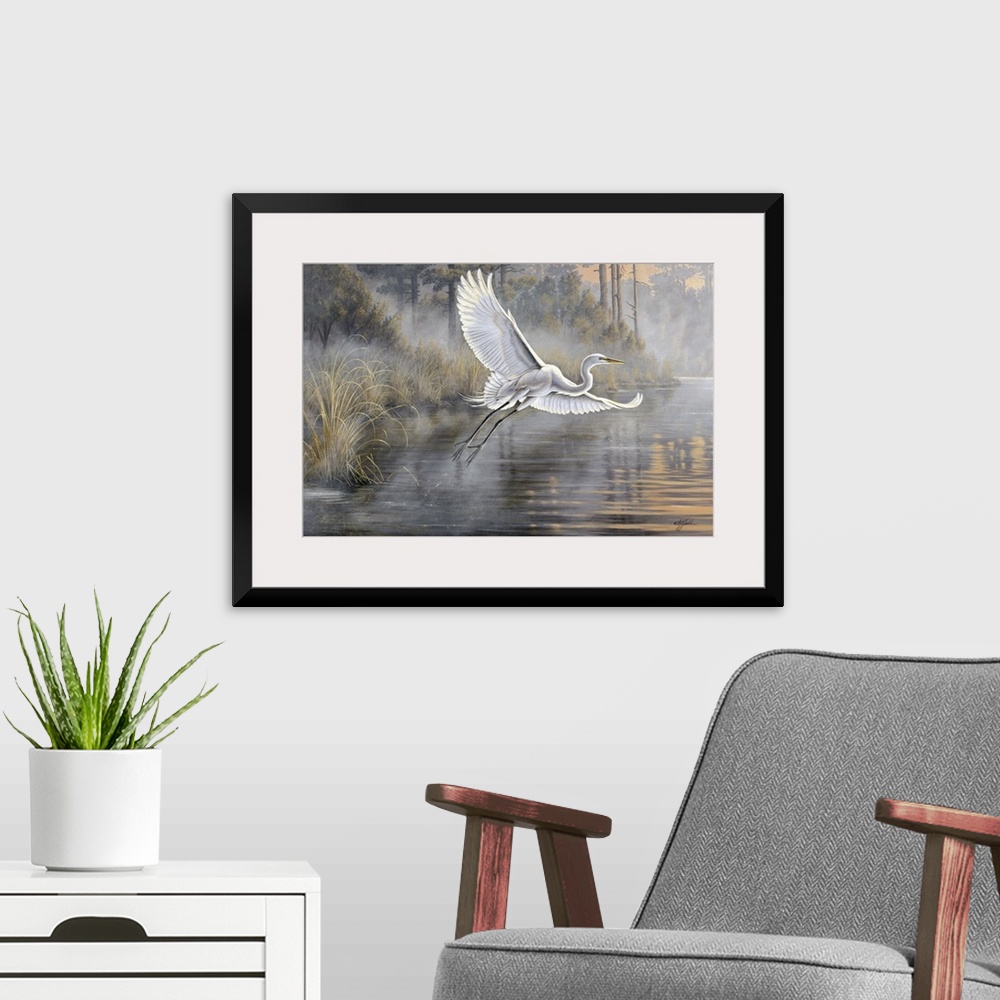A modern room featuring Great white egret flying over a pond at sunrise.