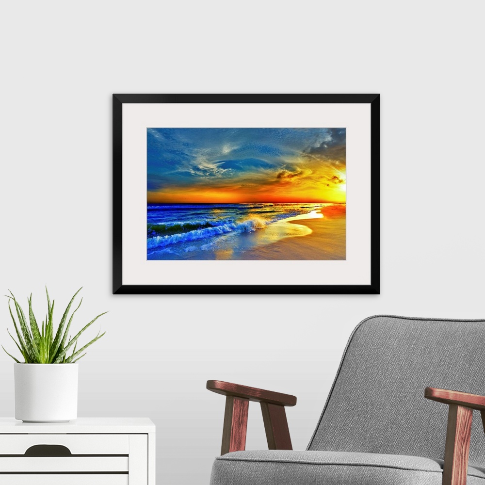 A modern room featuring A sandy beach before a bright burning red sunset.  Waves crash onto the sandy sea shore. Landscap...