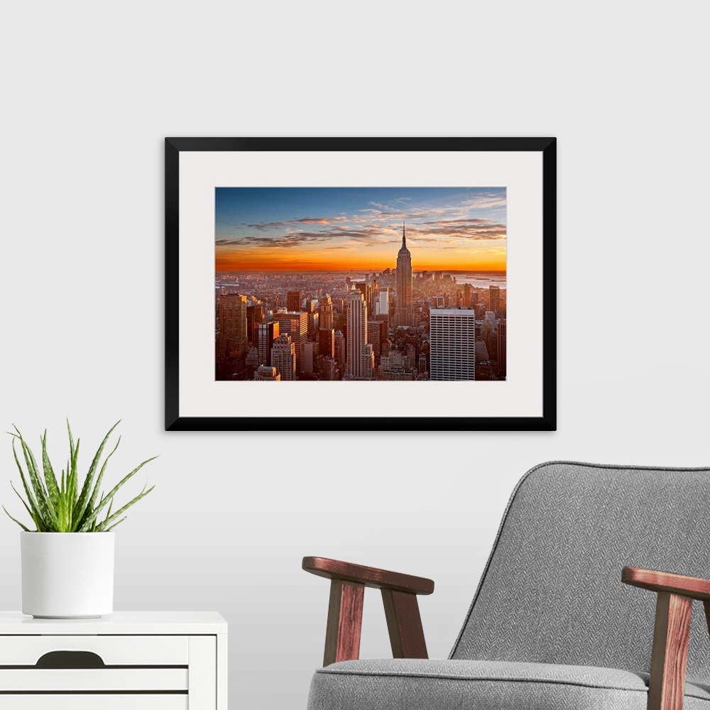 A modern room featuring Landscape orientation photograph of skyscrapers at the end of the day.