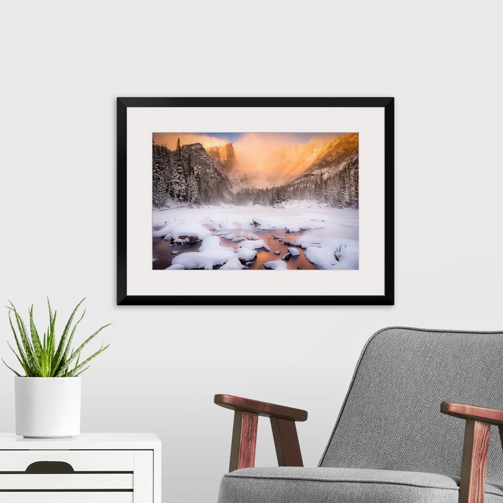A modern room featuring Giant photograph of a snow covered landscape filled with trees surrounding and a frozen river run...