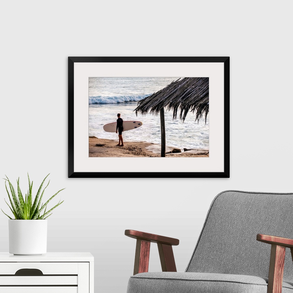 A modern room featuring Photograph of a surfer walking along the shore of the pacific ocean in San Diego, California, wit...