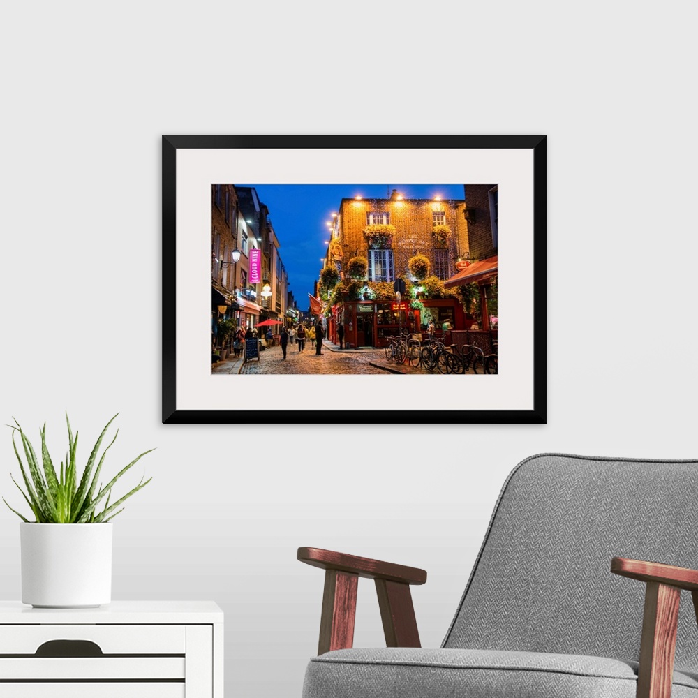 A modern room featuring Photograph of Temple Bar, a busy riverside neighborhood in Dublin, Ireland, at night.