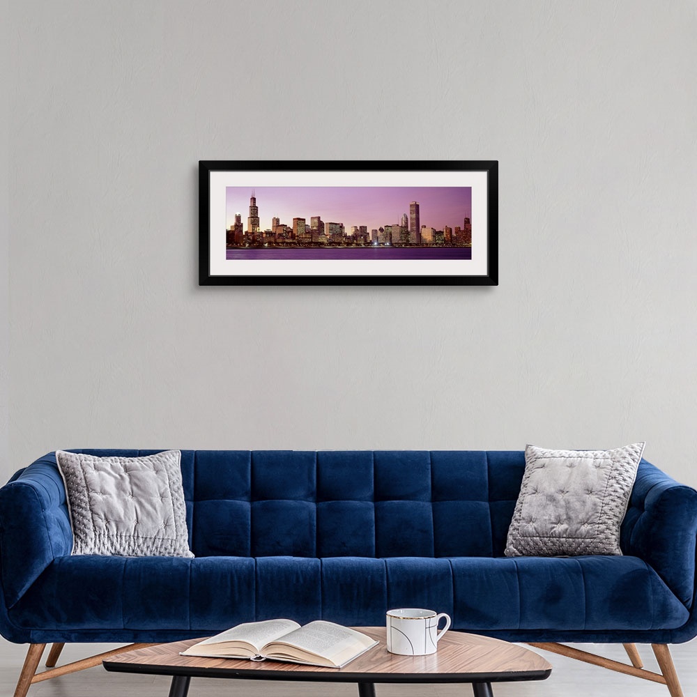 A modern room featuring The Chicago skyline lit up at night from across the water in Illinois.