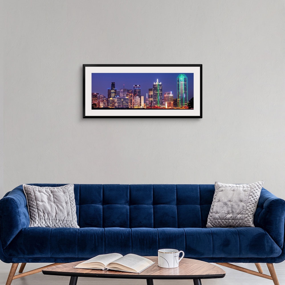 A modern room featuring A horizontal image of the Texas city skyline at night.