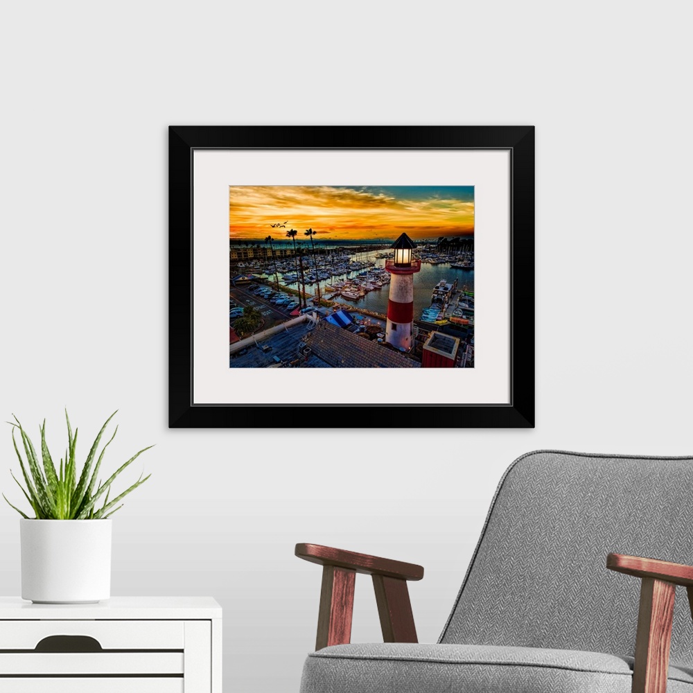 A modern room featuring Pelicans glide over the Oceanside Harbor and the little lighthouse glows. Colorful sunset in Ocea...