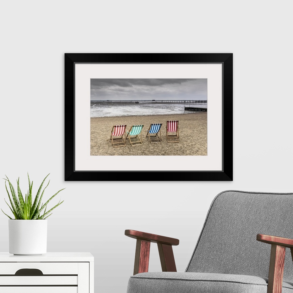 A modern room featuring Empty deckchairs on Jubilee Beach in Southend on a cloudy day.