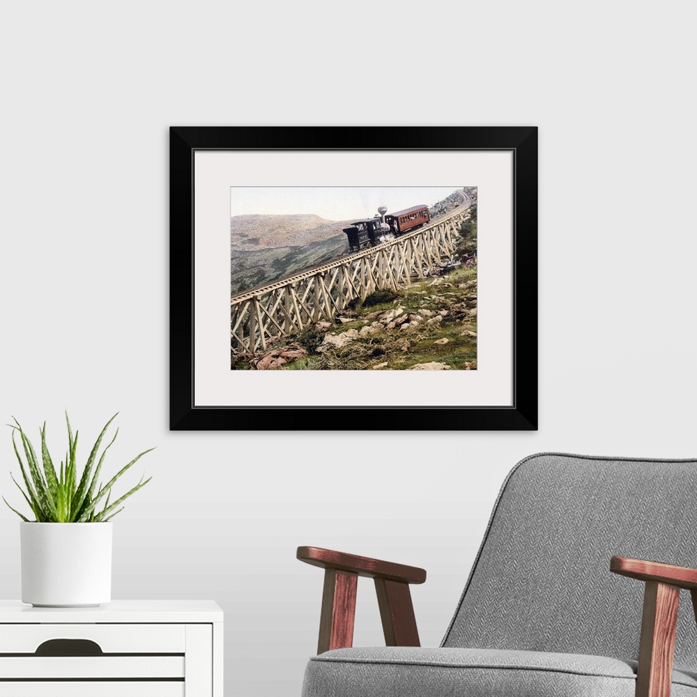 A modern room featuring A locomotive pushes a passenger car up a wood railway to the top of a mountain in this vintage la...
