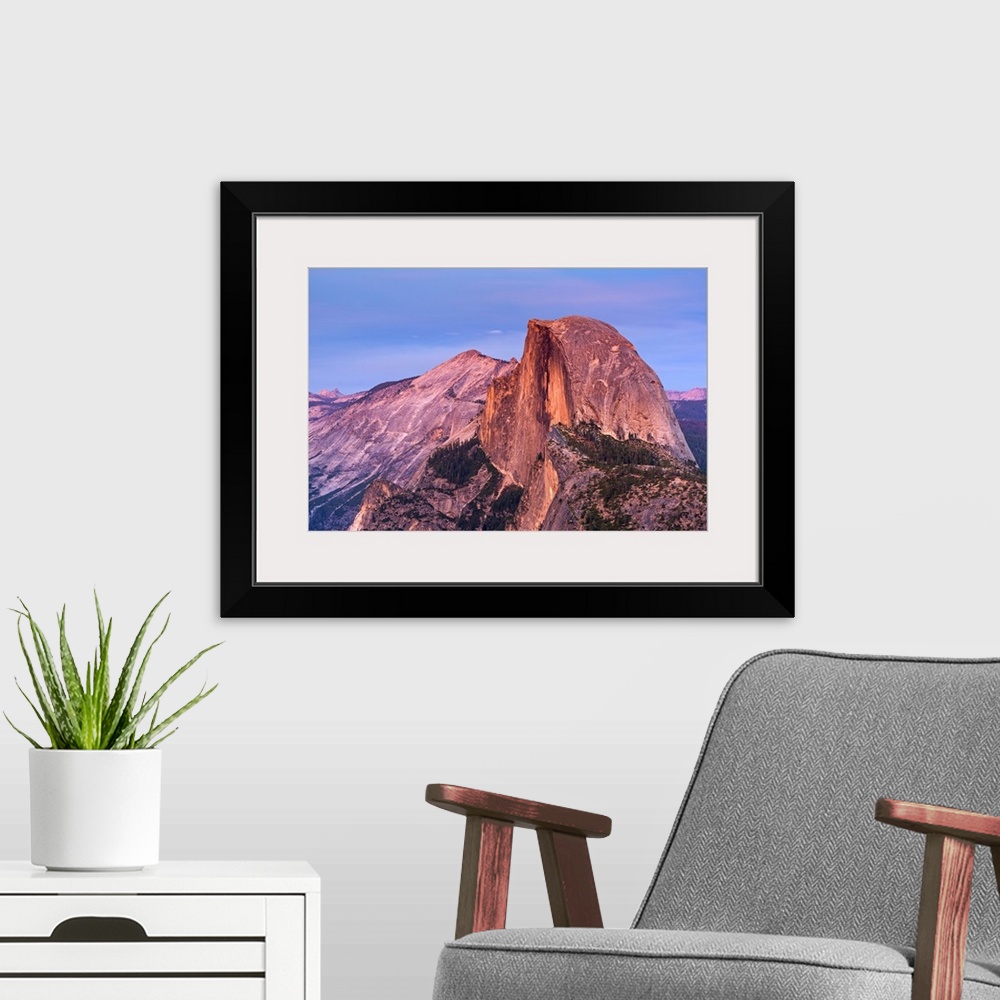 A modern room featuring Half Dome in Yosemite bathed in pink light from the sunset.