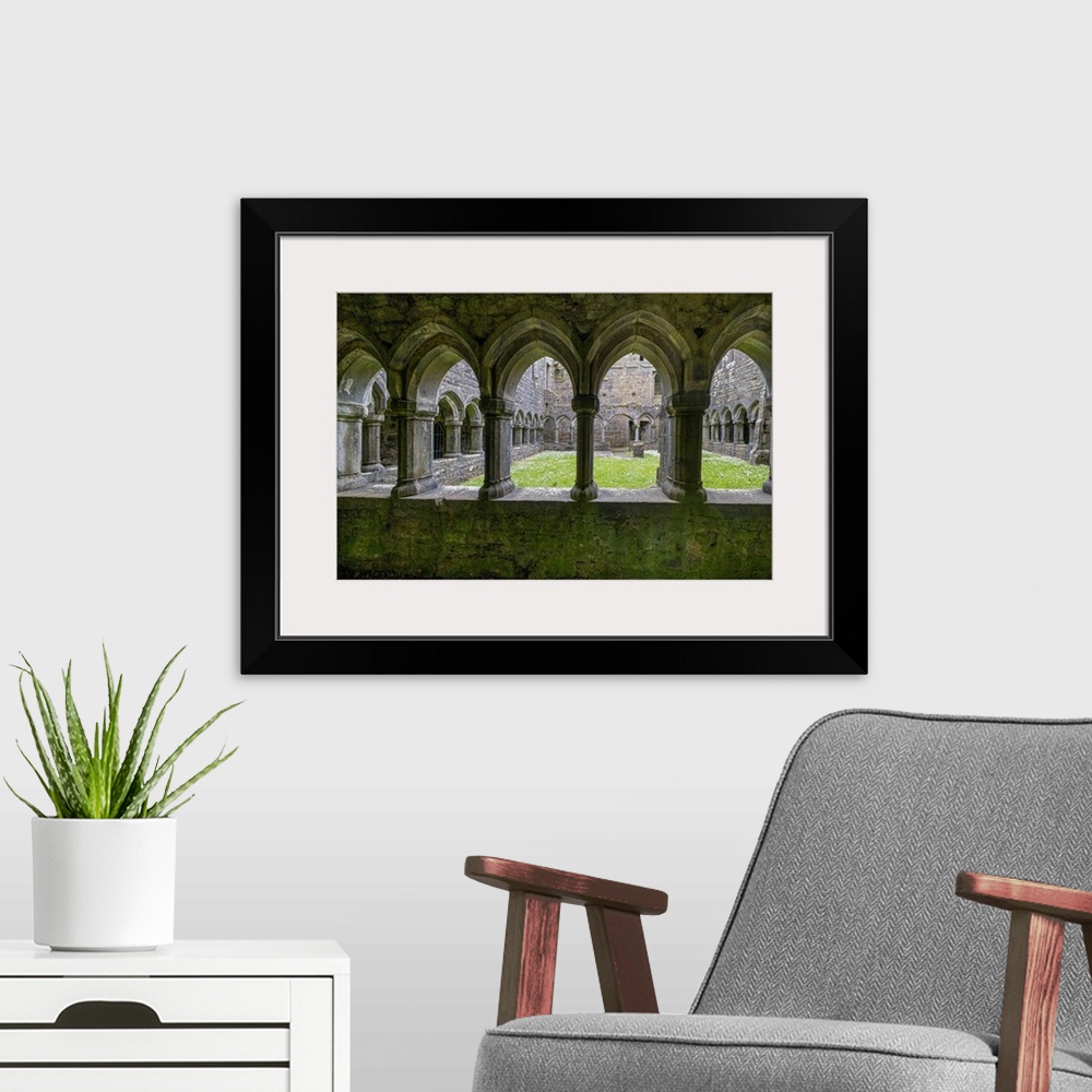 A modern room featuring Ancient cloisters surround this patch of grass at Moyne Abbey, County Mayo, Ireland.