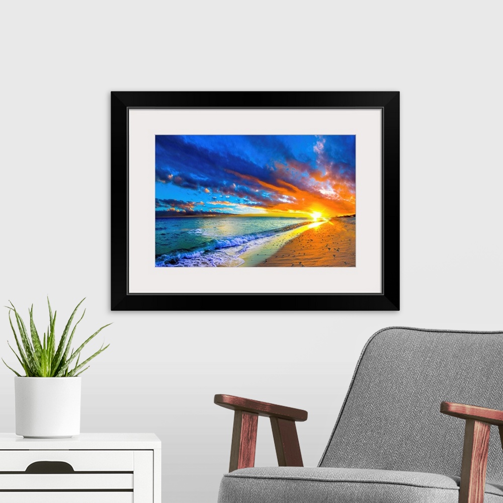 A modern room featuring A blue ocean sunrise with white crested waves. A colorful seascape sunset with an orange sun.