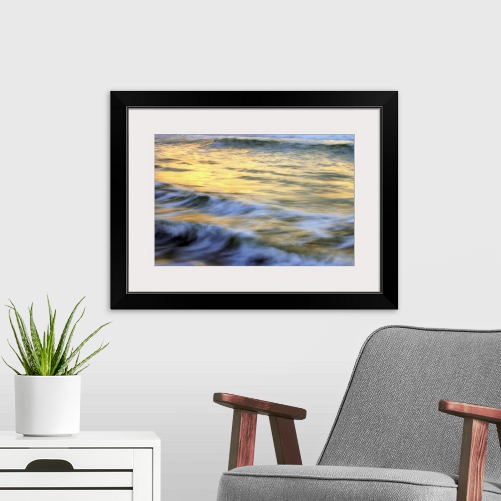 A modern room featuring Soft photograph of a sunset reflecting light on the ocean waves.