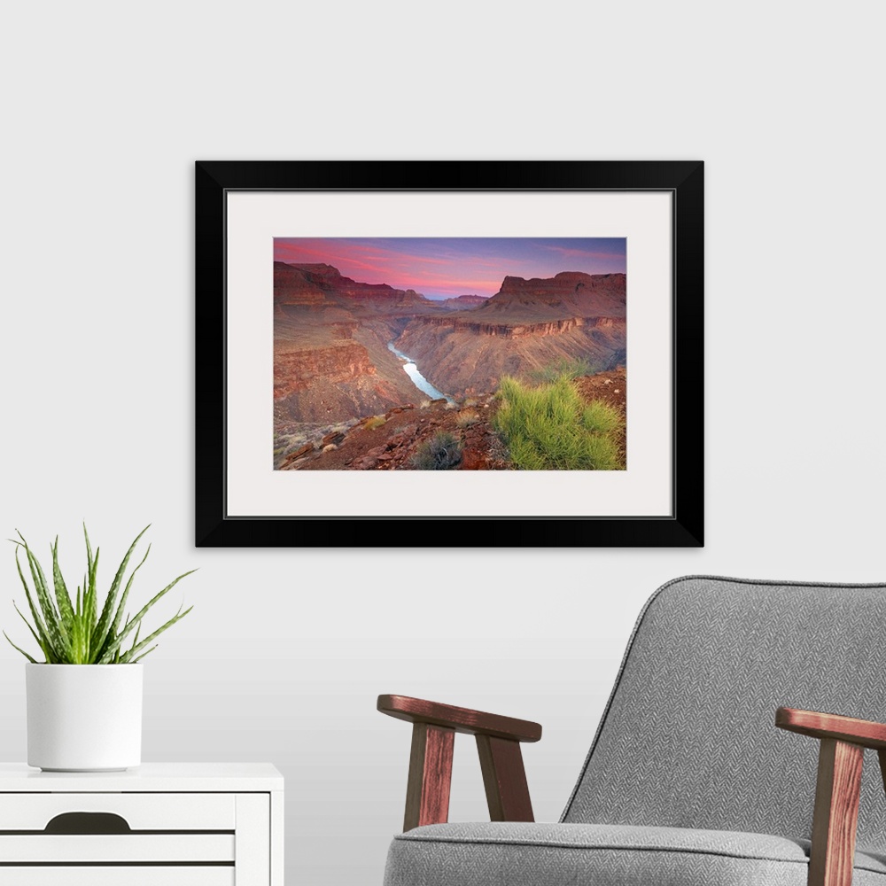 A modern room featuring The sun rises on the red rocks of the Grand Canyon as the Colorado River roars down below.