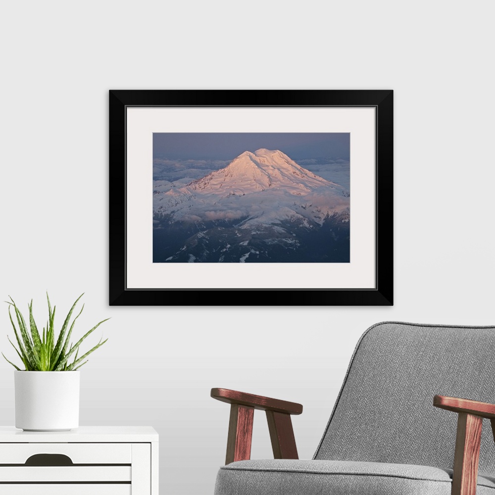 A modern room featuring Landscape, aerial photograph of a snow covered Mount Rainier, surrounded by clouds, a dark sky in...