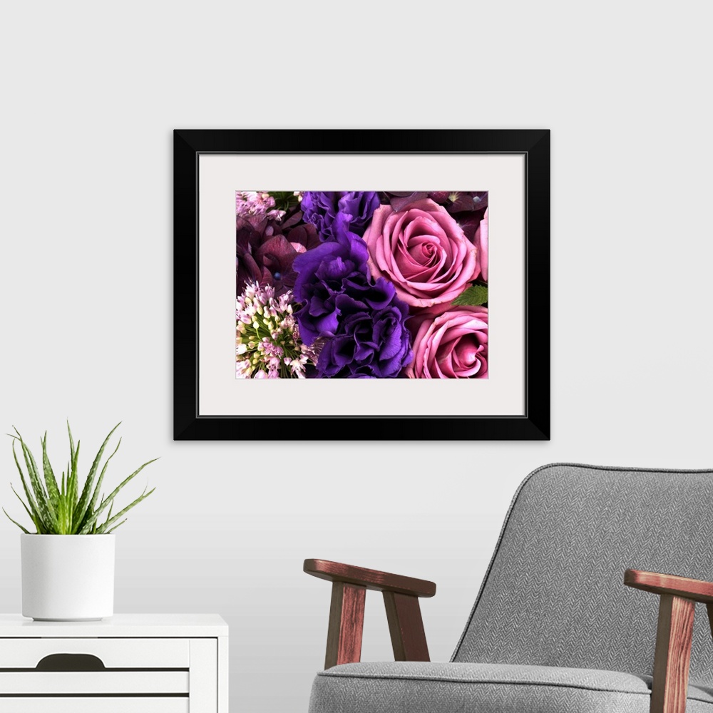 A modern room featuring Big canvas photo of different multicolored flowers arranged together.