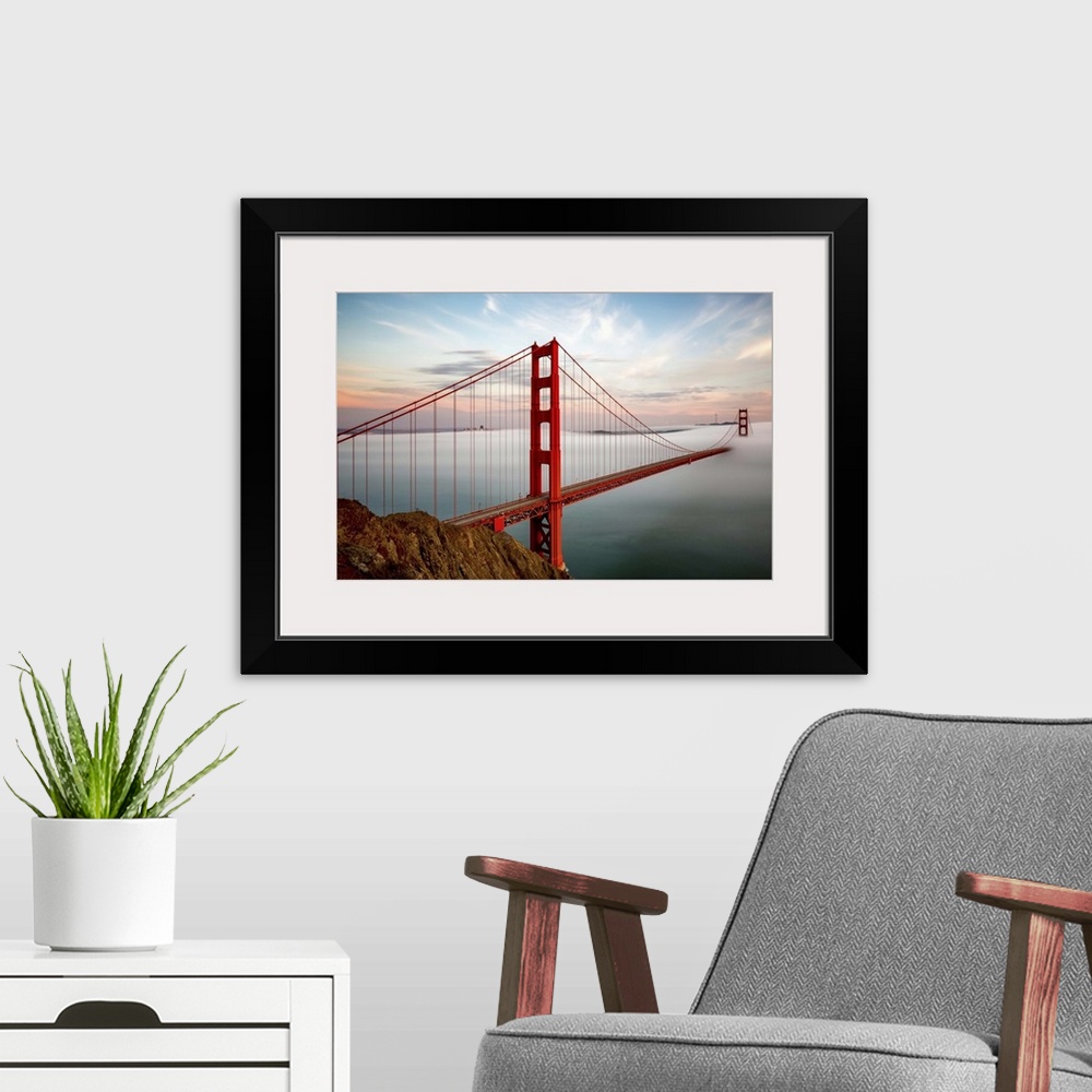 A modern room featuring The towers of the Golden Gate bridge in San Francisco, California, half-covered in mist.