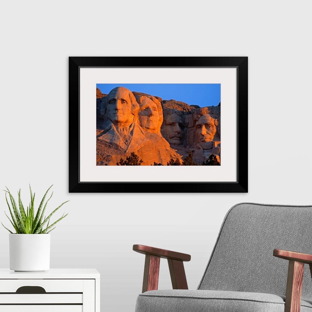 A modern room featuring A picture taken of Mount Rushmore as the sun begins to set and shines on the faces in the mountain.