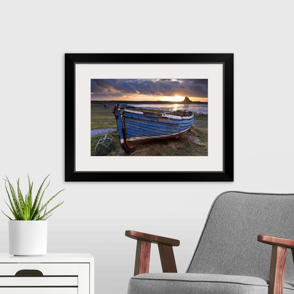 A modern room featuring Decaying fishing boat on Holy Island at dawn, with Lindisfarne Castle beyond, Northumberland, Eng...