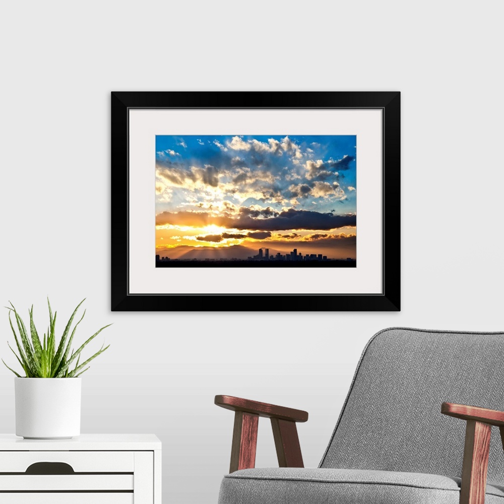 A modern room featuring Large photograph focuses on the sun's powerful rays trying to break through a sky scattered with ...