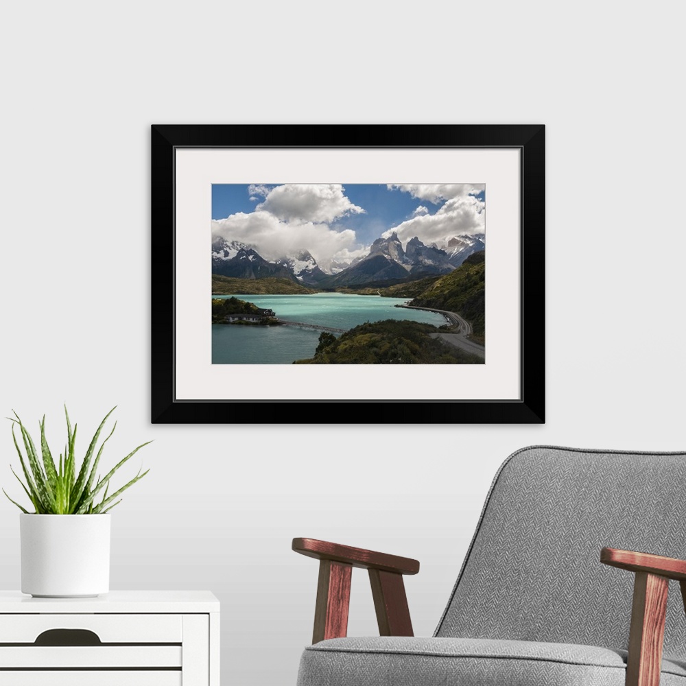 A modern room featuring Photograph of an idyllic wilderness scene, with a crystal blue lake and mountain spires surrounde...