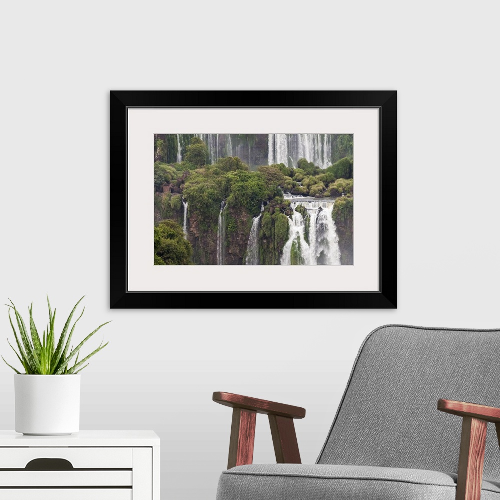 A modern room featuring Photograph of massive waterfalls flowing down over lush jungle cliffs.