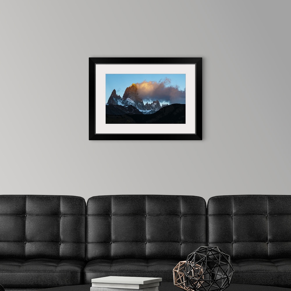 A modern room featuring Photograph of golden mountain spires in South America illuminated by the setting sun.