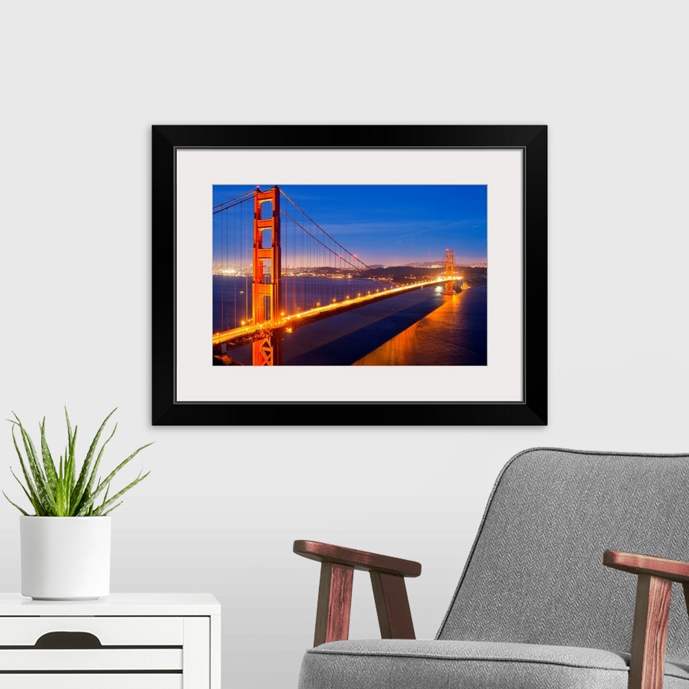 A modern room featuring The Golden Gate Bridge illuminated at night.