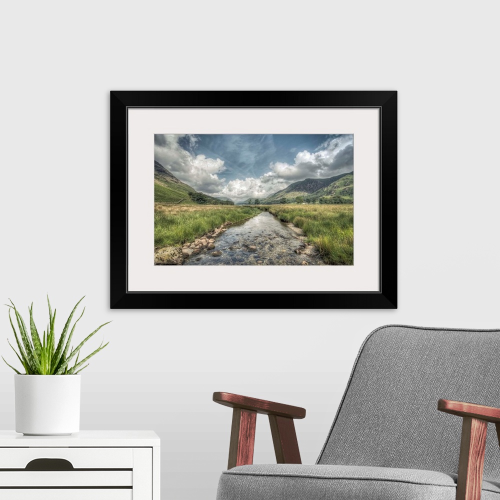 A modern room featuring HDR photograph of an idyllic countryside landscape looking toward a mountain range.