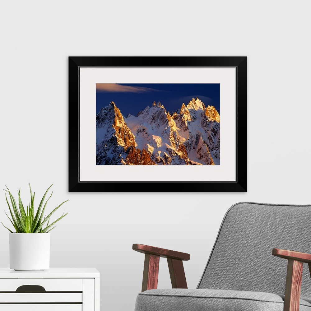 A modern room featuring Big photograph taken of snow covered mountains in the Alps of France.