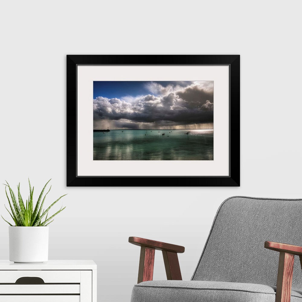 A modern room featuring An epic photograph of a swarm of large dense clouds moving over the French coast.