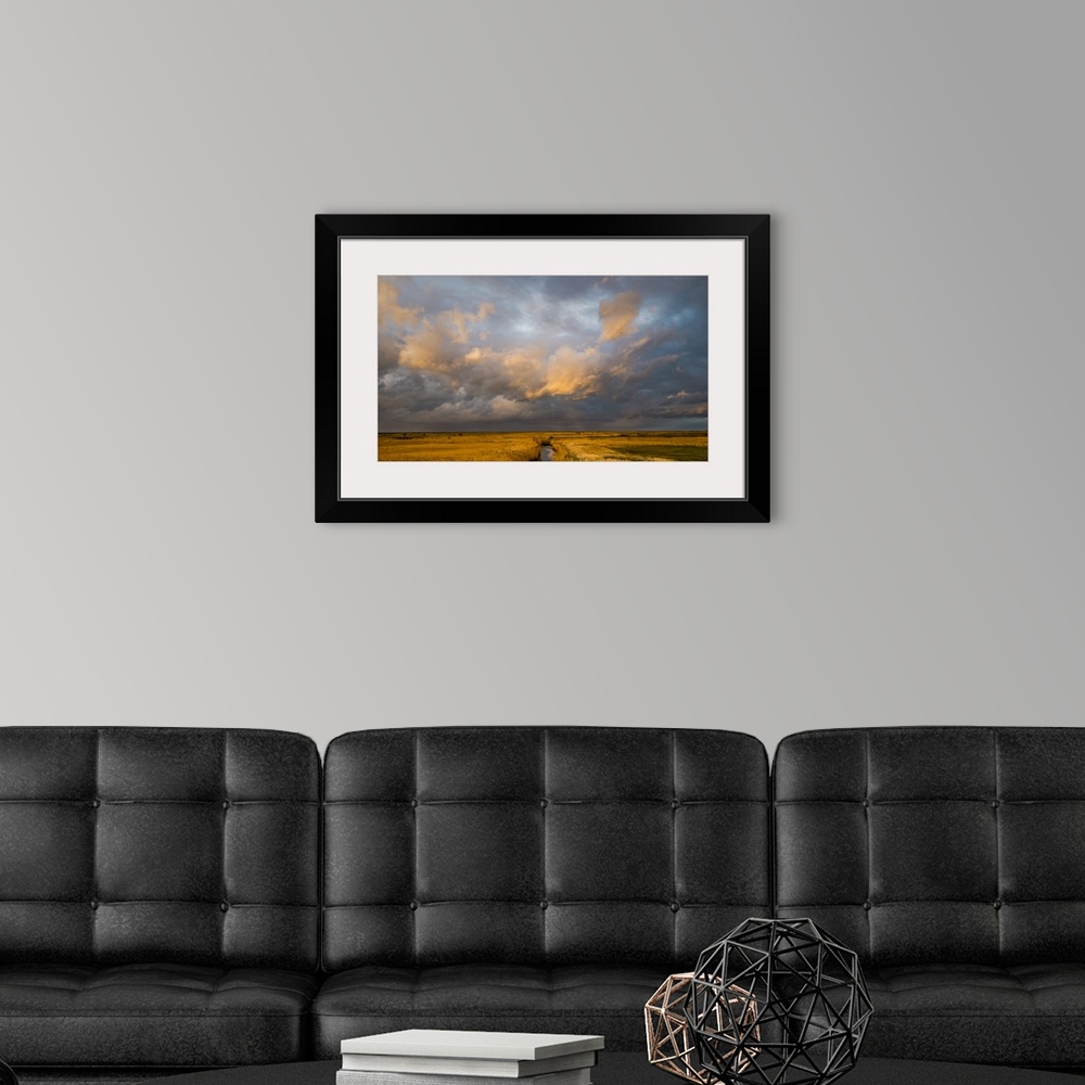 A modern room featuring Photograph of a beautiful skyscape in Norfolk, England, with a stream in the center moving toward...