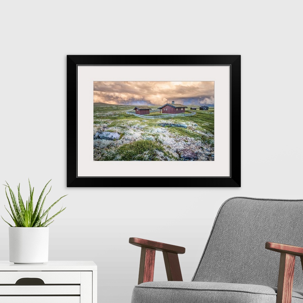 A modern room featuring A photograph of a Norwegian landscape with post storm clouds hanging overhead.