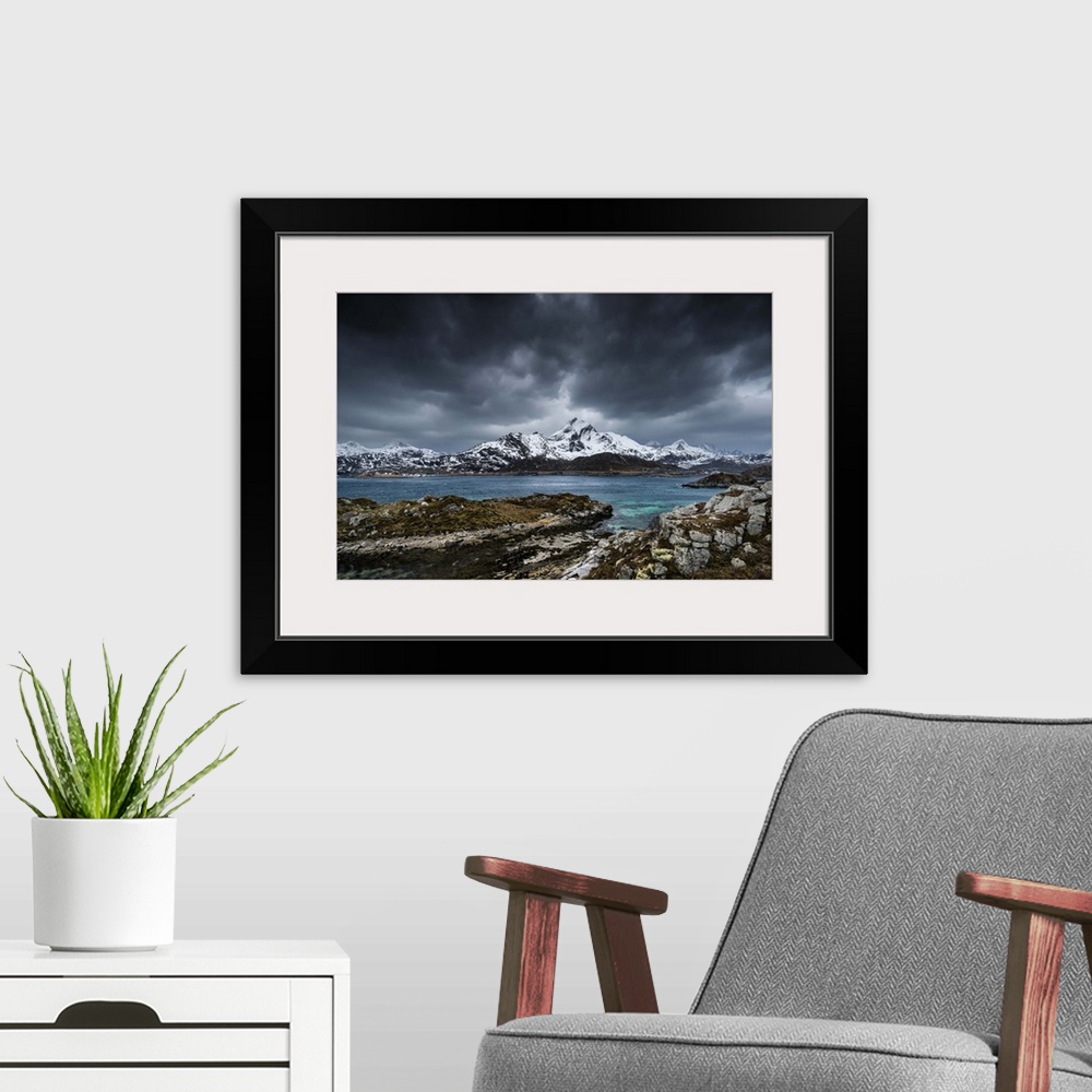 A modern room featuring A photograph of a mountain range seen from across a lake in winter.