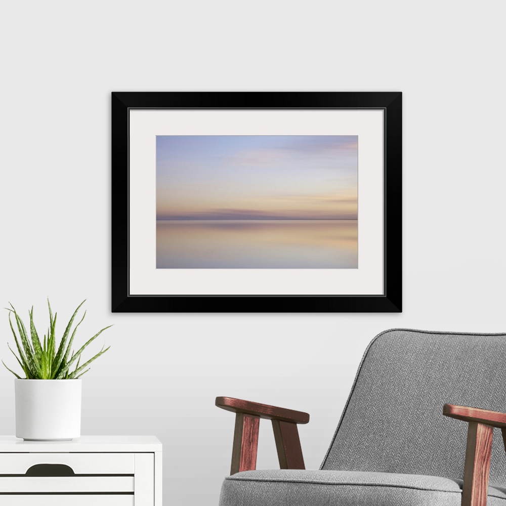 A modern room featuring Artistically blurred photo. Sunlit clouds are flirting with their pastel colored reflection in th...