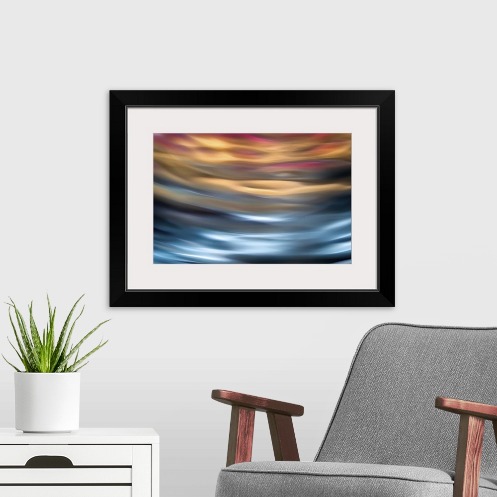 A modern room featuring Abstract photograph in orange and blue shades resembling ocean waves.