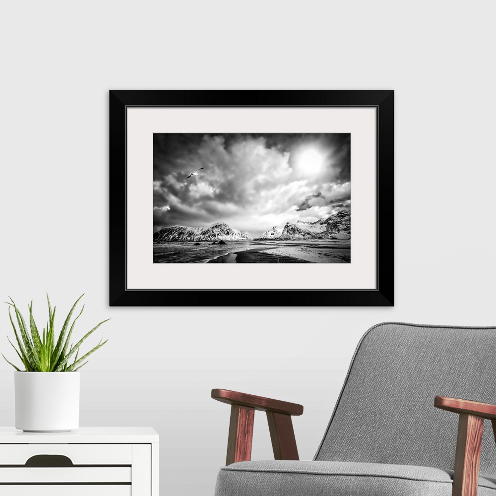 A modern room featuring A black and white photograph of a rugged mountainous landscape under a blanket of ornate and omin...