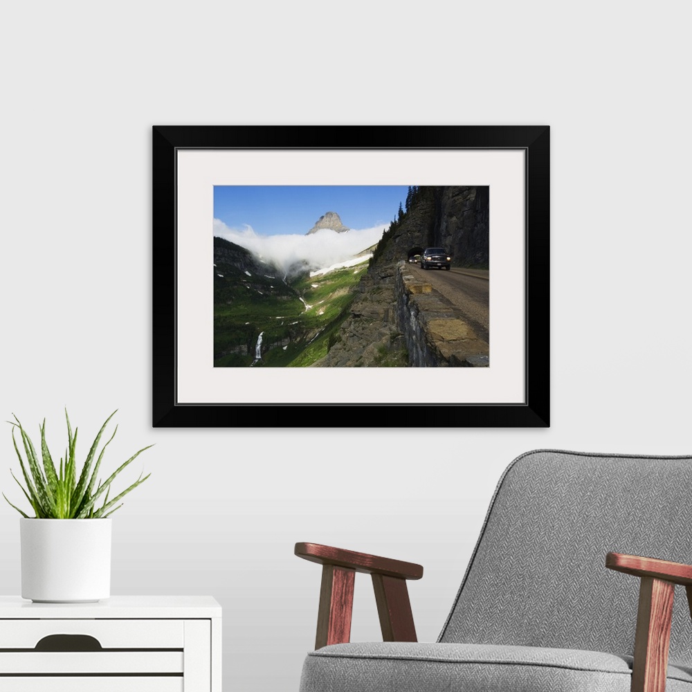 A modern room featuring Cars on Going to the Sun Road through mountainside tunnel, low clouds in valley, Glacier National...